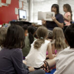 Maestra enseñando un texto a sus alumnos