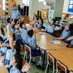 Alumnos y profesor alegres en sala de clases